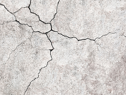 gray concrete wall with cracks texture as a background for design