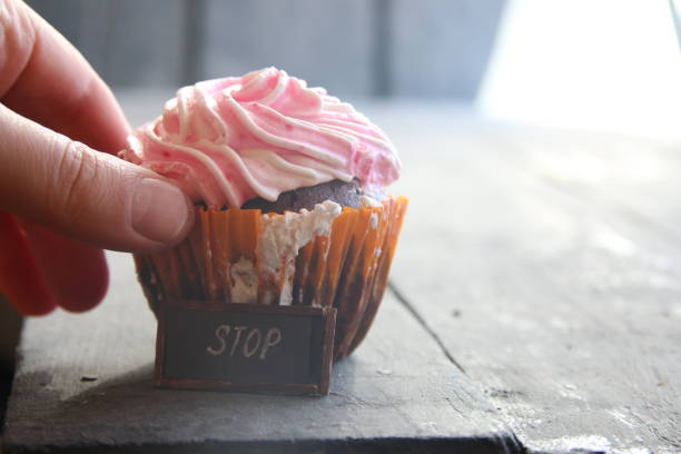 pink Cupcake on the old vintage wooden table and text Stop - diet idea