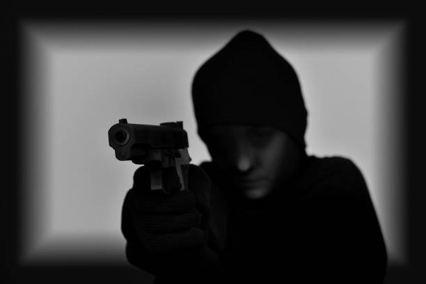 istock Female robber holding a gun 640007082