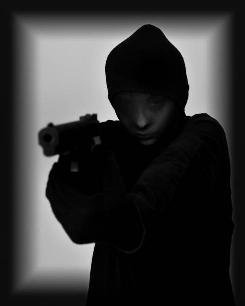 istock Female robber holding a gun 640007200