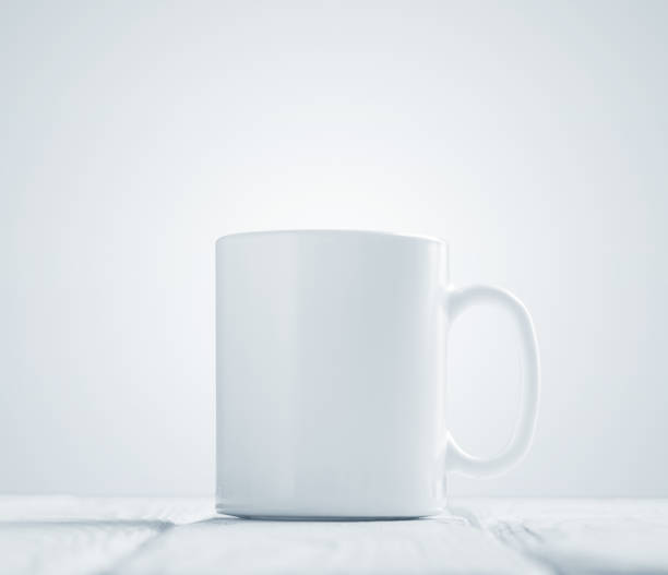 istock White cup mock-up inclined on wooden table 640009702