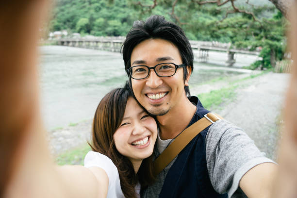 istock Cheerful Japanese couple taking selfie outdoors in a park 640013000