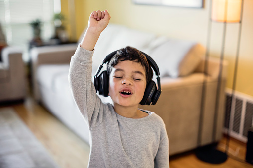 Stock photo of a child listening to music on wireless headphones