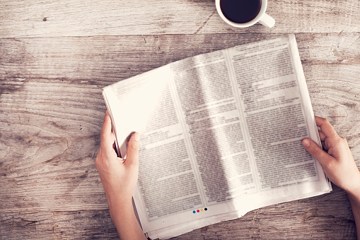 Young woman reading newspaper