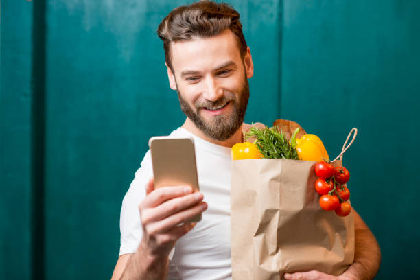 uomo che acquista cibo online - paper bag groceries food vegetable foto e immagini stock