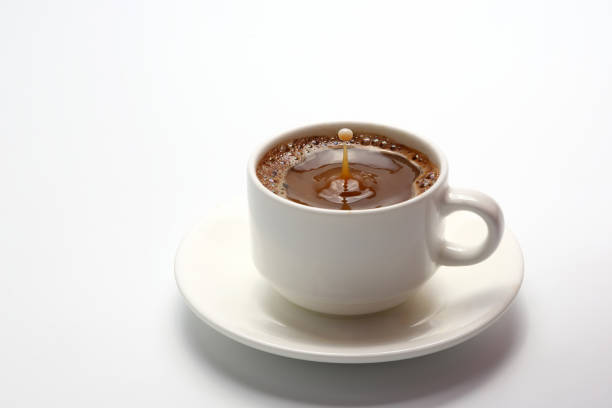 istock drop of milk falling in a cup with black coffee 640024066