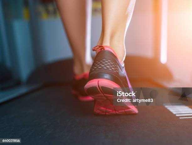 Female Muscular Feet In Sneakers Running On The Treadmill Stock Photo - Download Image Now