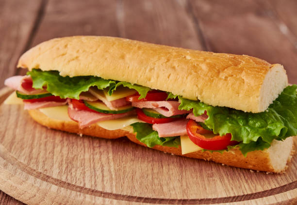 istock Submarine sandwich with ham, cheese, tomatoes, lettuce, cucumbers and onions 640031960