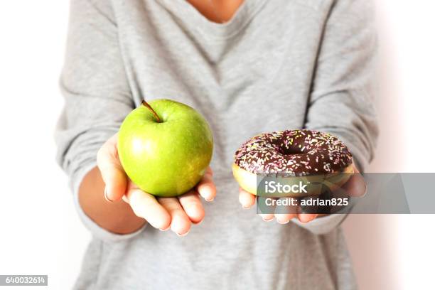 Dieting Concept With Woman Choosing Between Healthy Fruits And Donut Stock Photo - Download Image Now