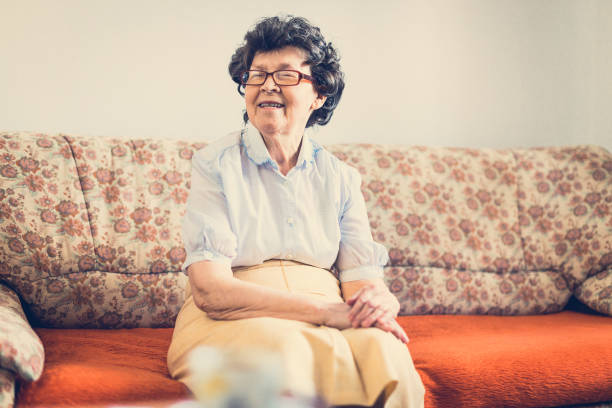 istock Aging with smile - senior woman sitting on couch 640032822