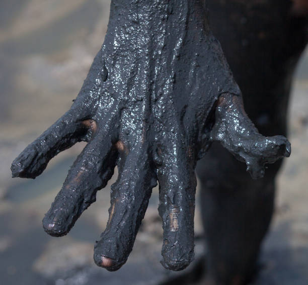 Hand smeared with black healing mud