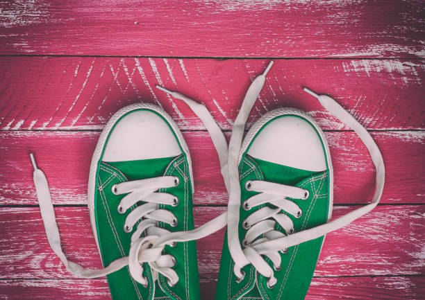istock pair of worn sneakers on a pink old wooden surface 640045874