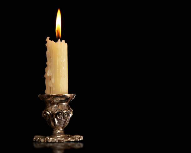 burning old candle vintage Silver bronze candlestick. Isolated Black Background. stock photo