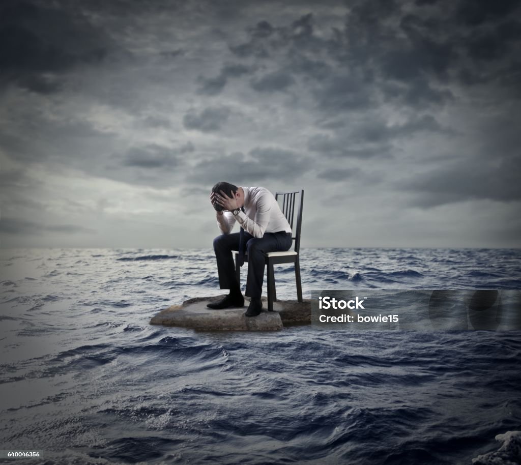 The waves of life Man is sitting on a chair in the middle of the ocean Businessman Stock Photo
