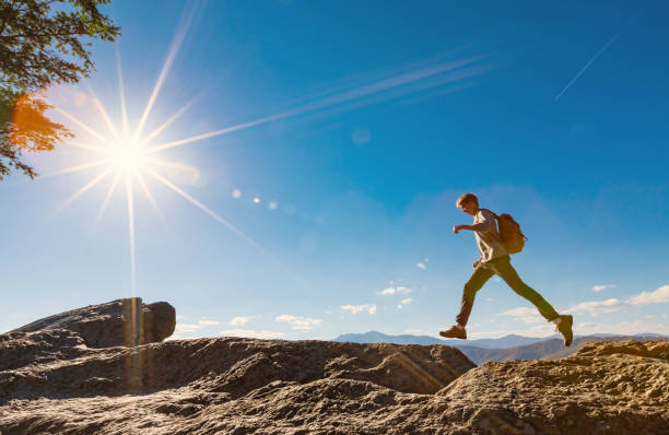 istock Man jumping over gap on mountain hike 640047300
