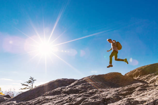 istock Man jumping over gap on mountain hike 640047320
