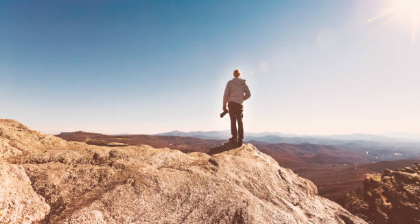 istock Man with a camera on top of a cliff 640047410