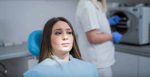 belle jeune femme inquiète et effrayée en attente d’un examen dentaire - dentist teenager dental hygiene sitting photos et images de collection