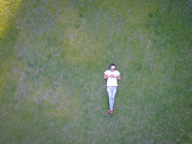 istock Lying on the grass and enjoying my virtual reality headger 640056478