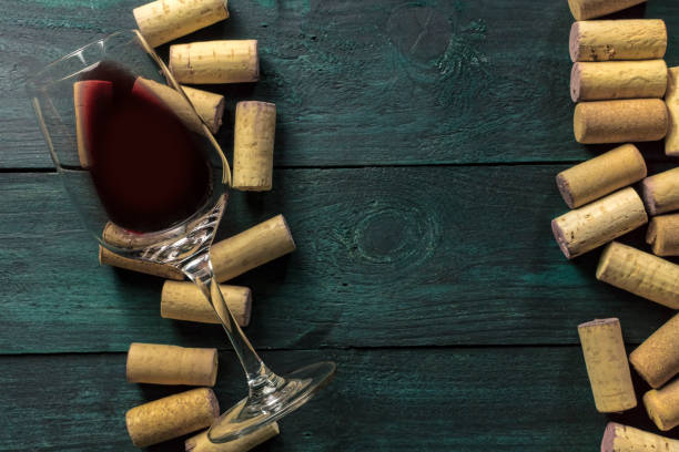 istock Glass of red wine and corks on dark background 640057018