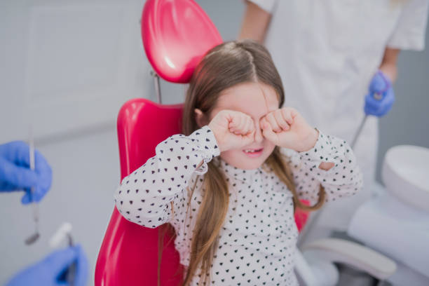 istock Cute young girl crying and refusing to cooperate with dentists 640057502