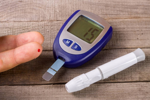 istock blood glucose meter with a hand on an old wooden 640061204