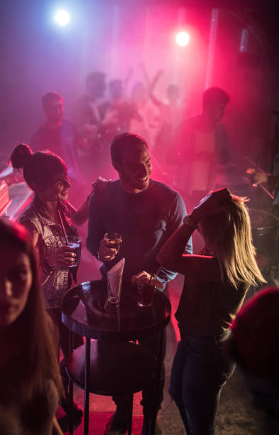 istock Smiling friends communicating while dancing in disco club. 640064190
