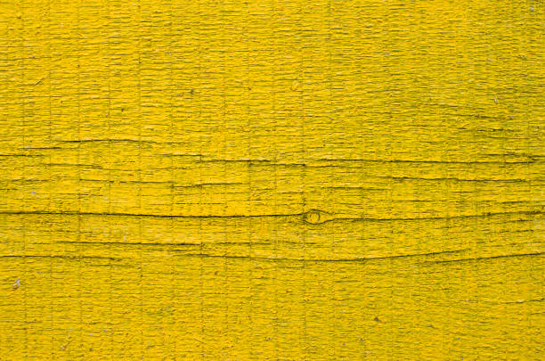 New yellow painted board with knot and cracks closeup