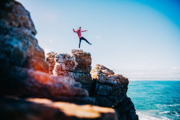 istock Young man balancing on cliff at the ocean 640069354