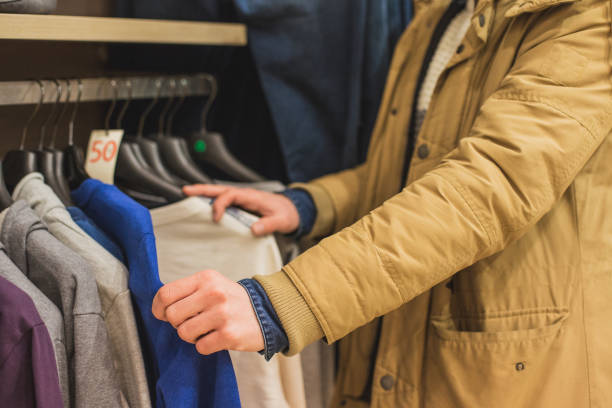 istock Young man browsing at clothing on rack in boutique 640070778