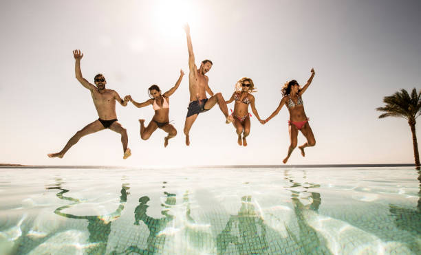 istock Playful people jumping together into the swimming pool. 640070920