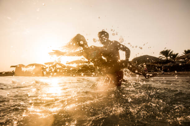 istock Happy couple having fun while playing in the sea. 640071426