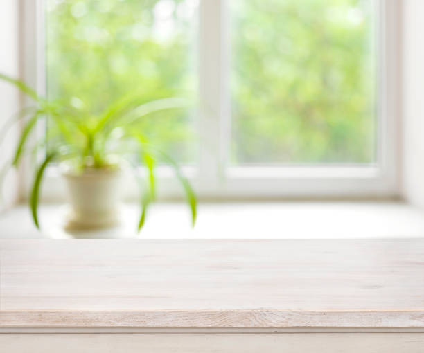 istock Light wooden table on defocuced summer window background 640071748