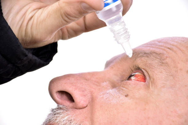 istock Senior man dripping a red eye with eye drops 640072308
