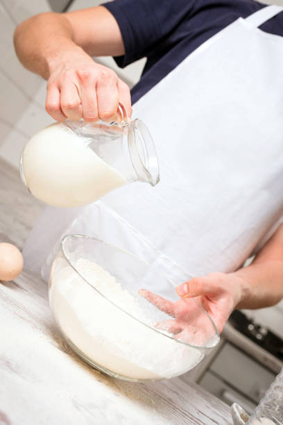 istock chef cook pours milk in a glass 640075918