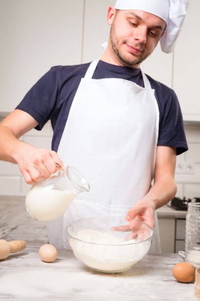 istock chef cook pours milk in a glass 640075948