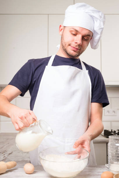 istock chef cook pours milk in a glass 640075988