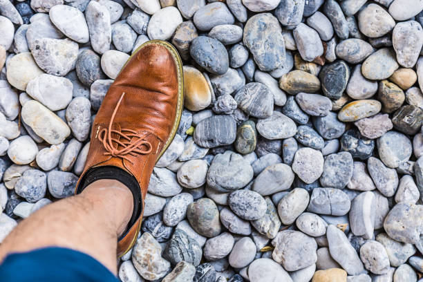 istock men leather shoe on round pebble stone background 640076694