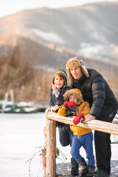 Father and sons having winter fun in the lake