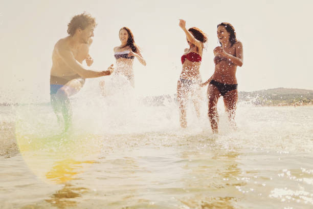 istock Group of young people playing in the sea 640079324