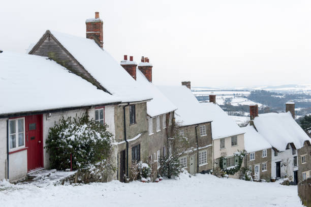 Gold Hill, Shaftesbury, Dorset, UK in winter The famous Gold Hill, in Shaftesbury, North Dorset in winter. Location for the making of the Hovis bread advert. Taken in the winter months with covering of snow, cloud cover and good visibility into the distance. shaftesbury england stock pictures, royalty-free photos & images