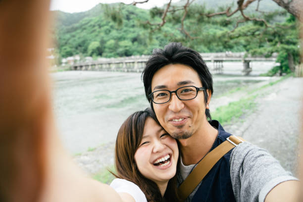 istock Cheerful Japanese couple taking selfie outdoors in a park 640085992