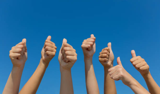istock Group of hands giving thumbs up over blue sky 640086004