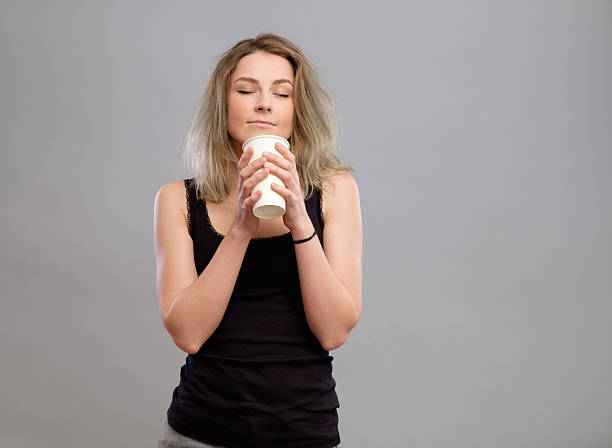 Woman enjoying hot drink in disposable paper cup