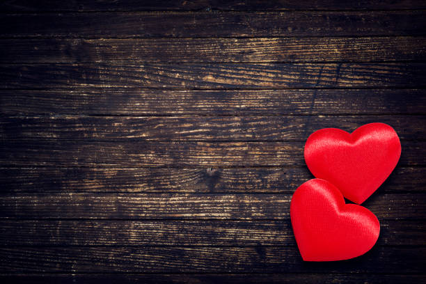 istock Two red hearts on brown weathered wooden table 640092468