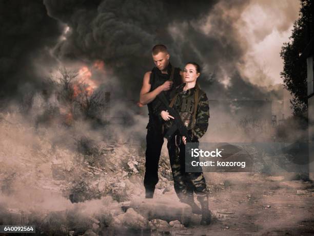 Girl And Man In Military Camouflage Uniforms Among The Ruins Stock Photo - Download Image Now
