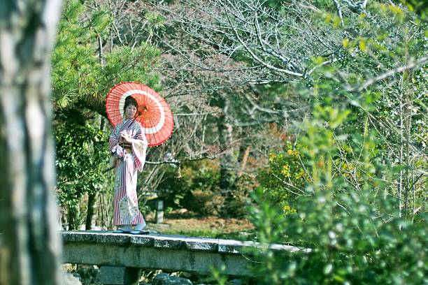 mujer en kimono con paraguas en un jardín japonés - japanese ethnicity seijin no hi people outdoors fotografías e imágenes de stock