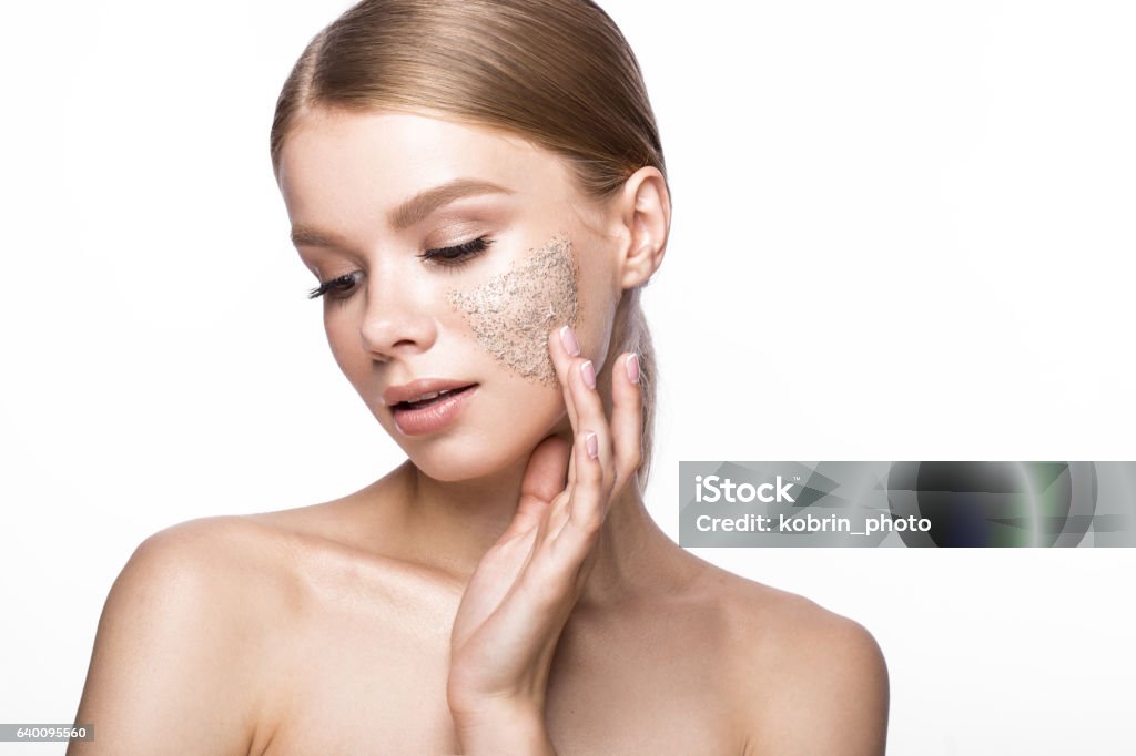 Beautiful young girl with scrub on the skin, French manicure Beautiful young girl with scrub on the skin and French manicure. Beauty face. Picture taken in the studio on a white background. Exfoliation Stock Photo