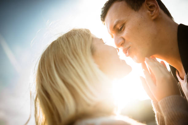istock romantic couple kissing at dusk with sunlight 640096122