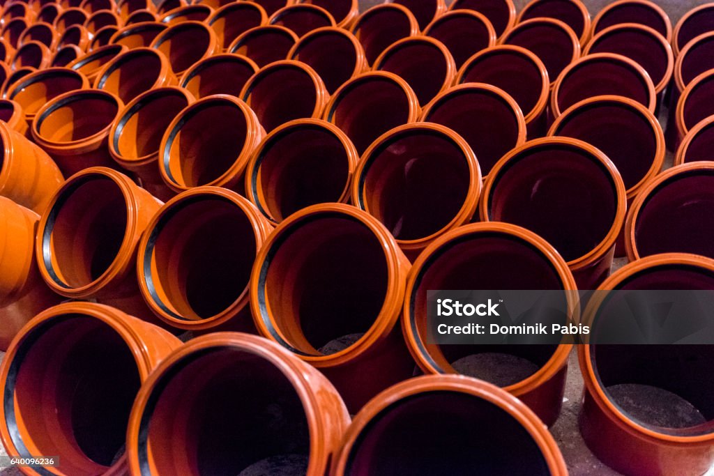 Group of plastic water pipes arranged in a row Large group of orange plastic water pipes arranged in a row on the floor. Arranging Stock Photo
